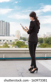 Thailand Business Woman On The Building Using Ipad Tablet Pc Computer Reading Ebook