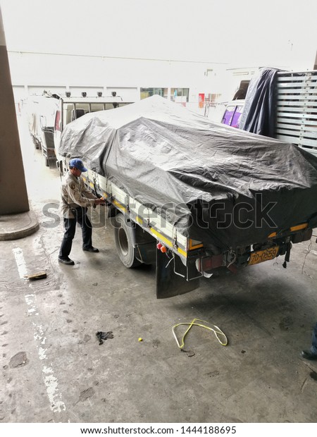 On​ 7​ JULY​ 2019​, At​ Bangkok​\
Thailand. Cargo staff will cover the rain tarp at the\
truck.