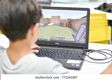 Thailand, December, 2017. The Young Asian Boy Is Focusing On His Minecraft Creative To Build Up His Land In The Coding For Kids Classroom In Thailand.