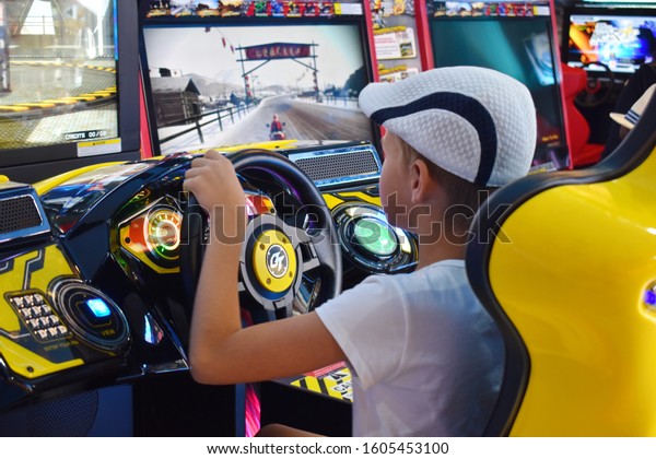 Thailand.\
Hua hin. January 2020. A boy plays computer games.  simulator\
machine games. Car racing game with the\
wheel.