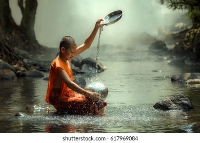 Thailand monk or novice monk sitting in the creek are wash container or bowl to clean - Powered by Shutterstock