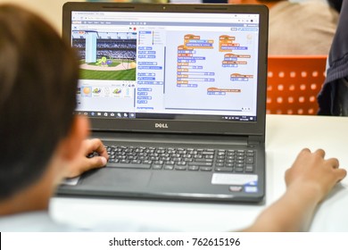 Thailand, November, 2017. The young Asian boy is checking his code by using the scratch program to run his game in the classroom.