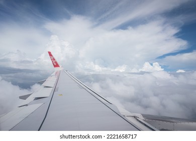 Thailand - October 2022 : An Air Asia Commercial Passenger Flight Is Flying In Little Cloudy Sky And Clearly Atmosphere. Transportation Industrial Editorial Photo.