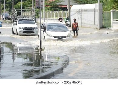 Thailand : October 24, 2021 flooding on Nakhon In Road, near the U-turn point Under Rama V Bridge, Nonthaburi Province Makes the traffic of the car difficult, with people helping in this area.