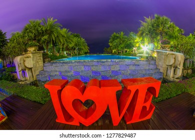 Thailand , Pattaya - January 1, 2019. Celebration of St. Valentine's Day on the tropical islands. luxury vacation. Inscription love and night lights on the background of exotic palms and night sky