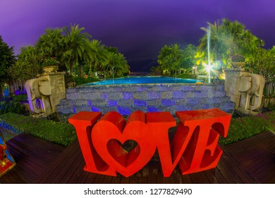 Thailand , Pattaya - January 1, 2019. Celebration of St. Valentine's Day on the tropical islands. luxury vacation. Inscription love and night lights on the background of exotic palms and night sky