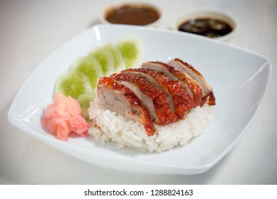 Thailand street food roasted duck topping on thai rice, Roasted bbq duck with gravy sauce on top of rice on white background