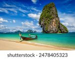 Thailand tropical vacation concept background - Long tail boat on tropical beach with limestone rock, Krabi, Thailand