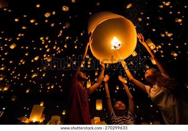 Thai's Family release sky
lanterns to worship buddha's relics in yi peng festival, Chiangmai
thailand