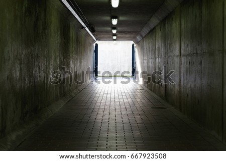 Thames Barrier passageway in London, a dim and concrete corridor leading to bright exit
