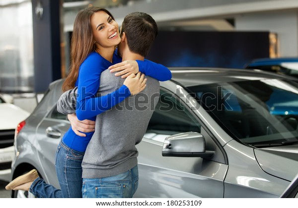 Thank you dear! Young beautiful woman hugging\
her boyfriend thanks for the new\
car