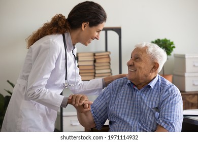 Thank you doctor. Smiling thankful mature sick man holding young female medic nurse hand appreciating for help support care. Happy woman gp greeting old man patient with recovery good analyses results - Shutterstock ID 1971114932