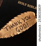 Thank You God, handwritten text on golden autumn leaf on top of holy bible book. Close-up. Christian biblical concept of gratitude and thanksgiving to Jesus Christ.