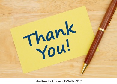 Thank You Message On Yellow Paper Index Card With Pen On Wood Desk