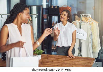 Thank you for shopping with us. Cropped shot of a cashier and a customer waving goodbye to each other. - Powered by Shutterstock