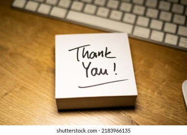 Thank You, Text Note. Office Desk With Notepad And Keyboard In The Background. In Black The Handwritten Text, Thank You. Gratitude, Respect And Encouragement.