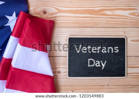 Thank You Veterans text written in chalkboard with  flag of the United States of America on wooden background. USA holiday of Veterans, Memorial, Independence and Labor Day