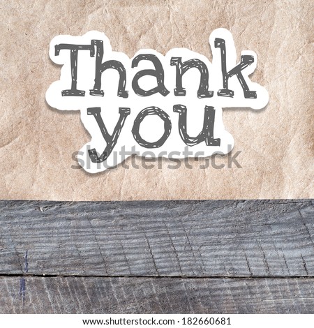 Thank You written on the paper on a wood background