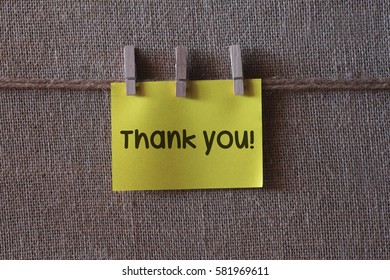 Thank you written on a wooden table and paper sticky notes.