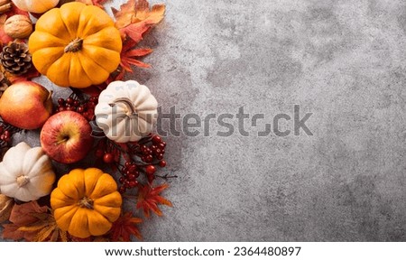 Thanksgiving and Autumn decoration concept made from autumn leaves and pumpkin on stone background. Flat lay, top view with copy space.