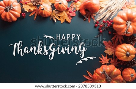 Thanksgiving and Autumn decoration concept made from autumn leaves and pumpkin on dark background. Flat lay, top view with copy space.