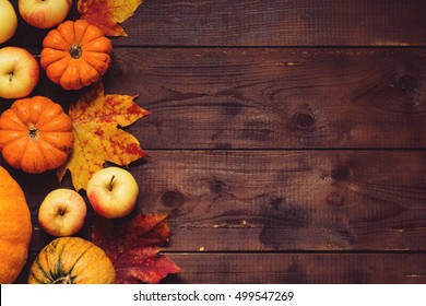 Thanksgiving background: Apples, pumpkins and fallen leaves on wooden background. Copy space for text. Halloween, Thanksgiving day or seasonal autumnal. Design mock up. Horizontal - Powered by Shutterstock