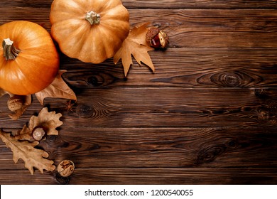 Thanksgiving Background Concept. Local Produce Pumpkin, Chestnut, Autumn Dry Oak & Maple Leaves And Anise For Decoration On Wood Textured Table. Close Up, Copy Space, Top View, Flat Lay.