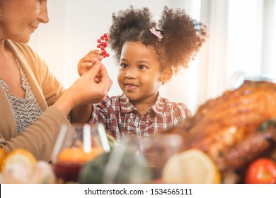 Thanksgiving Celebration Tradition Family Dinner Concept.family Having Holiday Dinner And Cutting Turkey.Young Black Adult Woman And Her Daughter Happy.