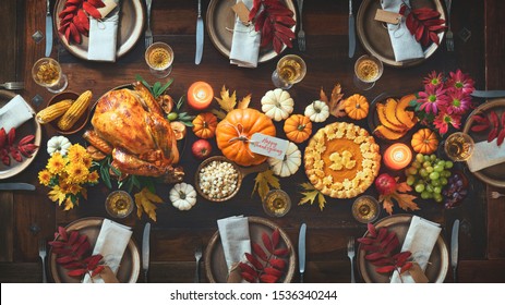 Thanksgiving Celebration Traditional Dinner. Roasted Turkey Garnished With Cranberries On A Rustic Style Table Decoraded With Pumpkins, Vegetables, Pie, Flowers And Candles. Festive Table Setting