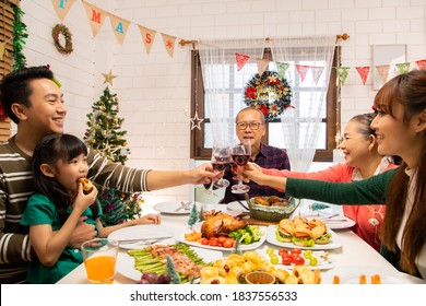 Thanksgiving Or Christmas Celebration Asian  Family Dinner Concept.Happy Family Having Holiday Dinner. Father Mother And Daughter, Having Dinner At Home. Elderly Parents During The Celebration .