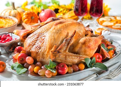 Thanksgiving Or Christmas Dinner. Roasted Turkey On Holiday Table With Pumpkins, Flowers And Wine