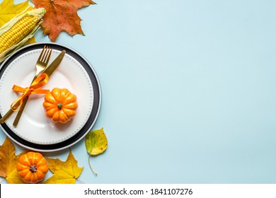 Thanksgiving Concept With Place Setting Pumpkins And Leaves On A Dinner Table