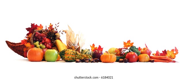 Thanksgiving cornucopia filled with autumn fruits and vegetables spread out to create a border.