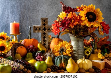 Thanksgiving cornucopia with pumpkins fruit flowers and wooden cross - Shutterstock ID 2057837102