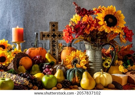 Thanksgiving cornucopia with pumpkins fruit flowers and wooden cross