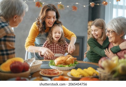 Thanksgiving Day, Autumn Feast. Happy Family Sitting At The Table And Celebrating Holiday. Grandparents, Mother And Children. Traditional Dinner.