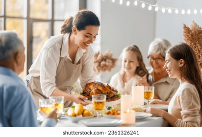Thanksgiving Day, Autumn feast. Happy family sitting at the table and celebrating holiday. Grandparents, mother and children. Traditional dinner. - Shutterstock ID 2361326241