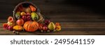 Thanksgiving day background with empty copy space. Pumpkin harvest in wicker basket. Squash, orange vegetable autumn fruit, apples, and nuts on a wooden table. Halloween decoration fall design.