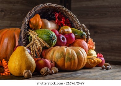Thanksgiving day close up still life. Pumpkin harvest in wicker basket. Squash, vegetable autumn fruit, apples, and nuts on a wooden table. Halloween decoration fall design. - Shutterstock ID 2169672499