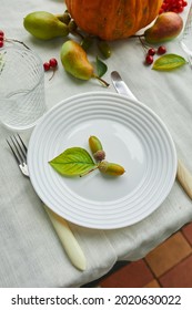 Thanksgiving Day Or Halloween Dinner Table Place Setting Decorative With Pumpkin, Acorns, Pears Leaves On White Tablecloth Background, View From Above, Top View, Flat Lay.
