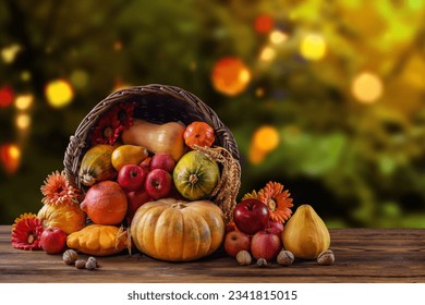 Thanksgiving day still life, background with empty copy space. Pumpkin harvest in wicker basket. Squash, vegetable autumn fruit, apples, and nuts on a wooden table. Halloween decoration fall design.