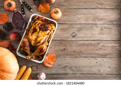 Thanksgiving dinner with chicken, cranberry sauce, seasonal vegetables and fruits on wooden table, copy space. Traditional autumn holiday food concept. - Shutterstock ID 1821404480