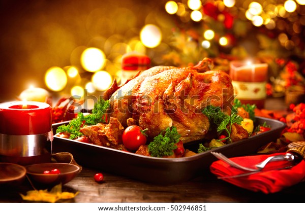 Thanksgiving dinner, Thanksgiving\
turkey. Served table. Thanksgiving table served with turkey,\
decorated with bright autumn leaves. Roasted turkey, table\
setting