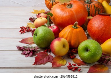 Thanksgiving Fall Centerpiece With Pumpkins, Autumn Leaves, Red, Green Apples On The White Wooden Background 