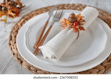 Thanksgiving fall table decoration; place setting centerpiece napkin arrangement with acorn and fall leaves on empty plates - Powered by Shutterstock