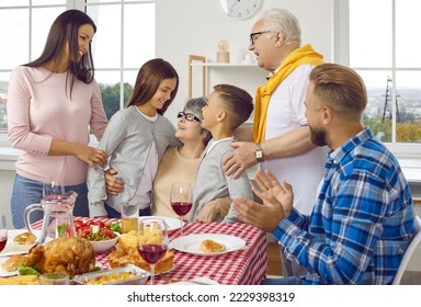 Thanksgiving family dinner. Multi-generational family is having fun while celebrating Thanksgiving and enjoying time together. Grandmother hugs her grandchildren. Holidays and celebration concept. - Powered by Shutterstock