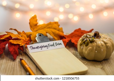 Thanksgiving Food Drive List Concept On Blank Clipboard Surrounded With Bright Leaves And Decorative Items Soft Background