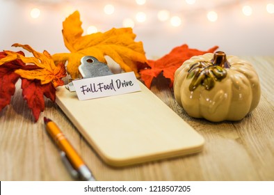 Thanksgiving Food Drive List Concept On Blank Clipboard Surrounded With Bright Leaves And Decorative Items Soft Background