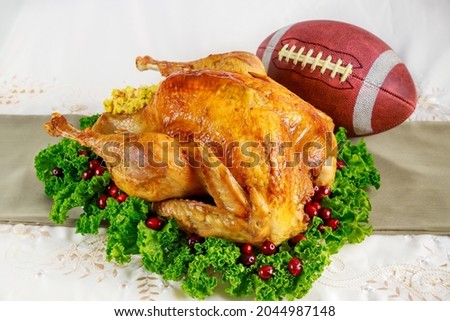 Thanksgiving football game concept. Festive roasted turkey with garnish.