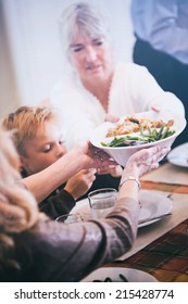 Thanksgiving: Grandmother Passing Side Dishes Across Table